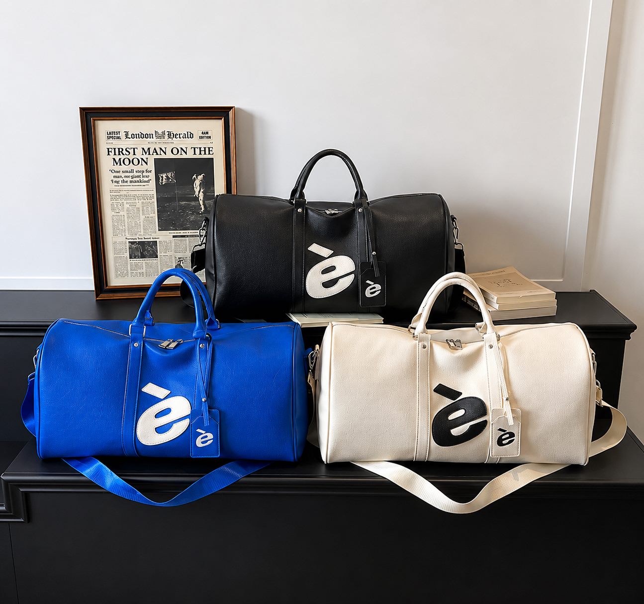 è weekender travel bags in cobalt blue, black and cream on a black sideboard