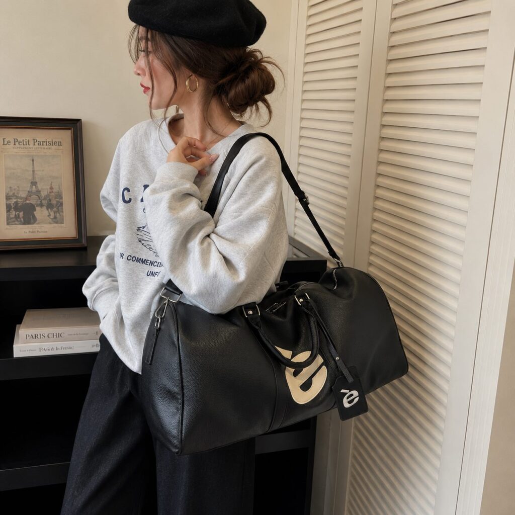 Woman carrying the black è Weekender bag on her shoulder