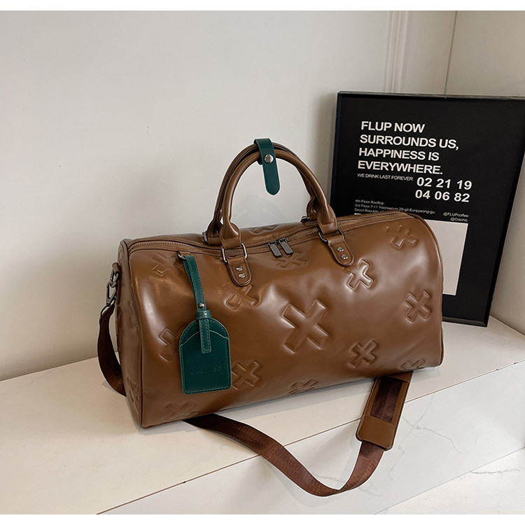 è Voyager embossed duffle bag in brown with green luggage tag
