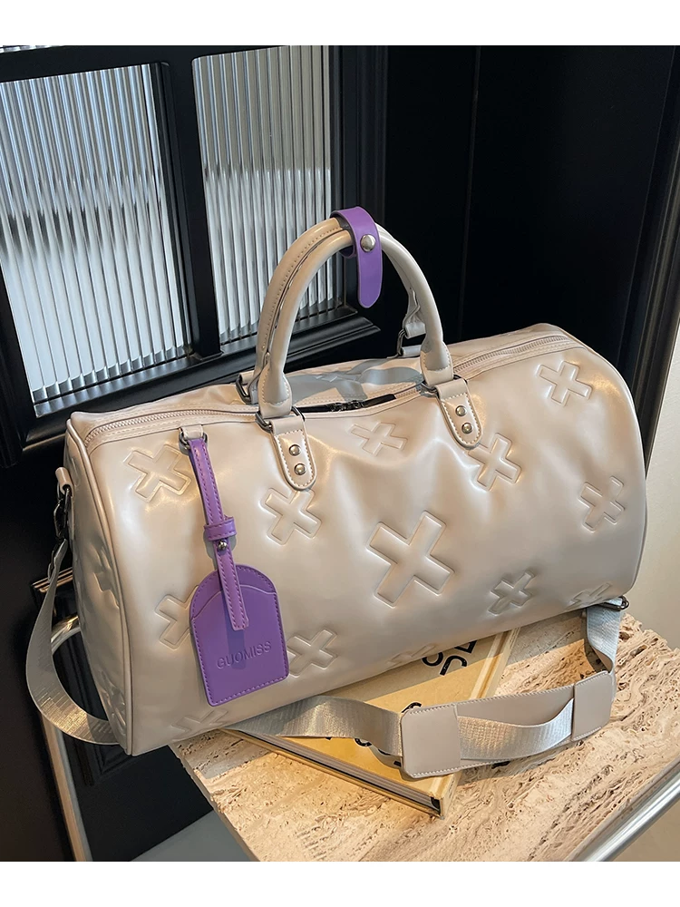 è Voyager embossed duffle bag in cream with purple luggage tag