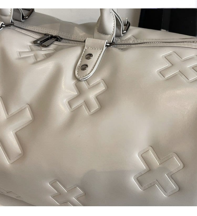 Close up of the embossed cross motif on the è Voyager duffle bag